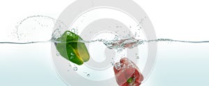 Two peppers splashing in water