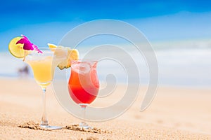 two perfect cocktails strawberry daiquiri and Margarita with lime and pineapple on top, beach background