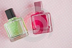two perfume bottles: pink and green
