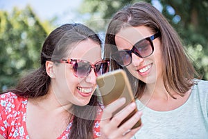 Two persons looking at smartphone surprised and happy by social media new exciting event news friendship concept lifestyle tech