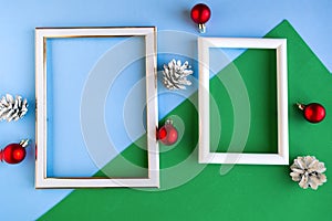 Two photo frames and Christmas decorations on color background, copy space for the text.
