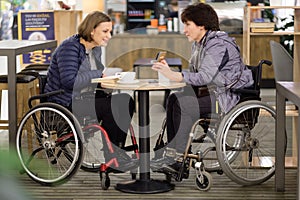 Two physically challenged women in a cafe