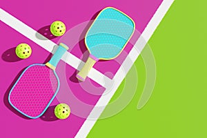 Two pickleball rackets and sports balls on the playground