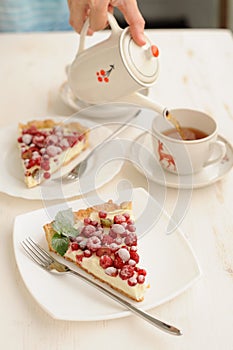 Two pieces of berry pie with whipped cream filling and a cup of tea