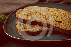 two pieces of black bread on a plate, horizontal, close-up, rustic style, vintage,