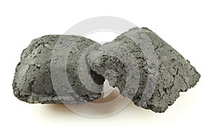 Two pieces of briquette isolated on white background. Close-up of small charcoal pieces