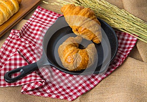 Two pieces of croissant on black ceramic pan that put on the fab