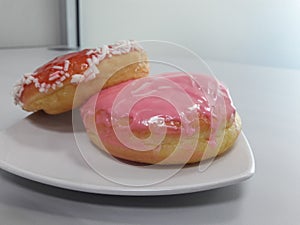 two pieces of donut served on a white plate on the table