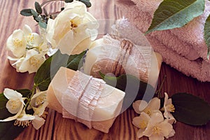 Two pieces of dry white soap with towels, roses and jasmine