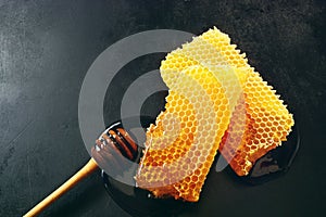 Two pieces of fresh honeycomb with a dipper