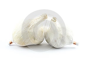 Two pieces of garlic in a plastic textures wrap on a white background