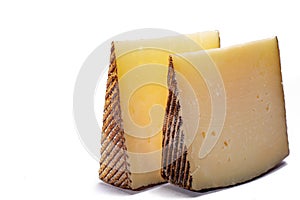 Two pieces of Manchego, queso manchego, cheese made in La Mancha region of Spain from the milk of sheep of the manchega breed, is