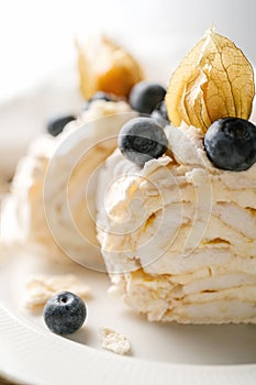 Two pieces of meringue roll with berries on a plate.