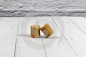 Two pieces of peanut candy on a white wooden table