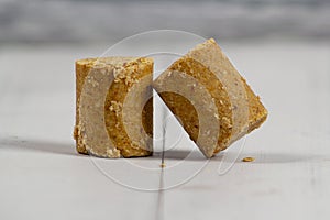 Two pieces of peanut candy on a white wooden table