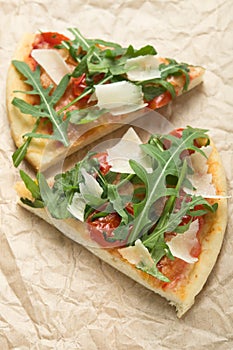 Two pieces of pizza with arugula