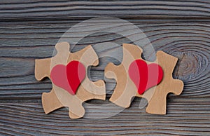 Two pieces of a puzzle with a red heart, unite into a single whole.