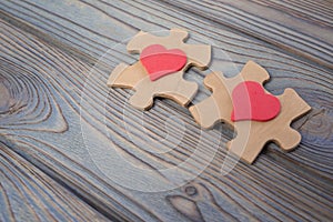 Two pieces of a puzzle with a red heart, unite into a single whole. Holiday, St. Valentine`s Day