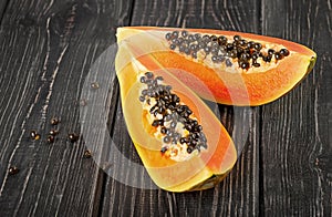 Two pieces of ripe papaya on a wooden table
