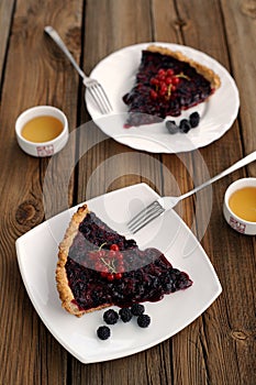 Two pieces of tart with black currant and blackberry filling and green tea