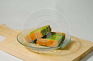 Two pieces of yellow-green lapis legit cake