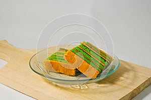 Two pieces of yellow-green lapis legit cake