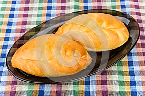 Two pies in black glass dish on tablecloth