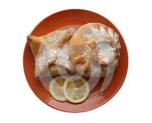 Two pies and lemon on a plate