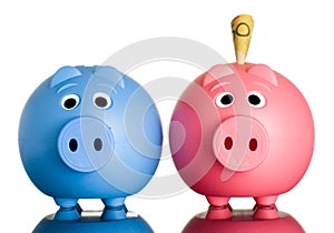 Two piggy banks with money in one.