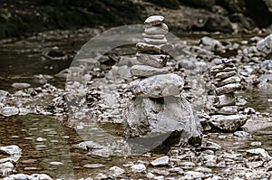 Two piles of stacked rocks, balancing in a riverbed, rock balancing