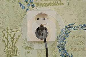 Two pin wall socket with double holes with plug in it