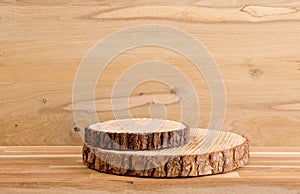 Two pine tree wood discs stacked as a podium for products  natural wood board background.