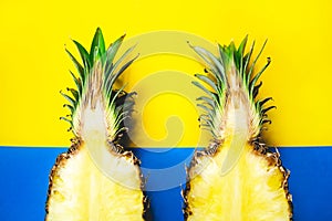 Two pineapple fruits half creative concept on blue and yellow background. Simbol of couple, love, friendship