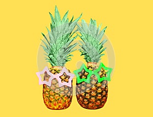 Two pineapple with sunglasses on yellow background