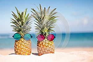 Two pineapples with trendy sunglasses in tropical paradise