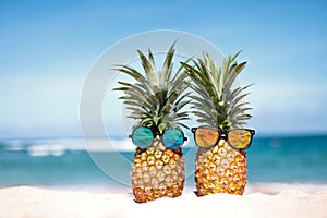 Two pineapples with trendy sunglasses in tropical paradise