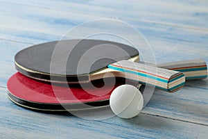 Two ping pong rackets. Table tennis rackets and a ball on a blue wooden table. sport game