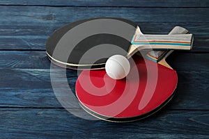 Two ping pong rackets. Table tennis rackets and a ball on a blue wooden table. sport game