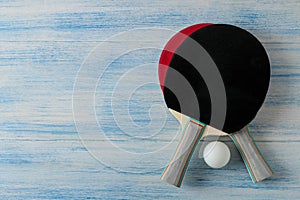 Two ping pong rackets. Table tennis rackets and a ball on a blue wooden table. sport game. top view