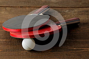 Two ping pong rackets. Table tennis rackets and a ball on a brown wooden table. sport game