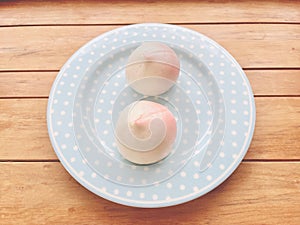 Two pink birthday peach buns on a blue plate. Chinese traditional birthday food.