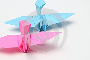 Two pink and blue paper birds, folded origami art.