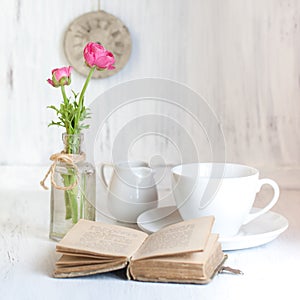 Two pink flowers ranunculus and old opening book