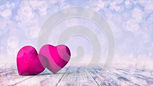 Two pink hearts on wooden deck with bright bokeh effect on light blue background.