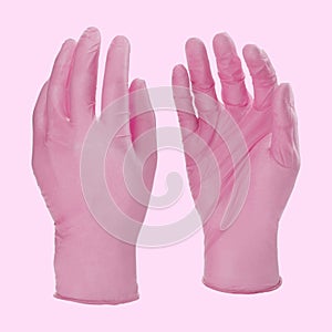 Two pink latex medical gloves isolated on white background with no hands