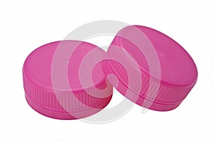 Two pink plastic bottle caps isolated on white background