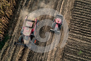 Two Pink Tractors Driving in Field