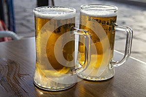 Two pint glasses with cold beer served outdoor