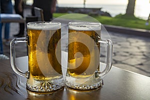 Two pint glasses with cold beer served outdoor