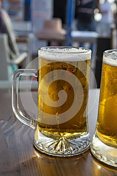 Two pint glasses with cold beer served outdoor